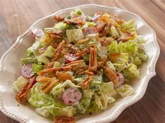 a white bowl filled with salad on top of a wooden table