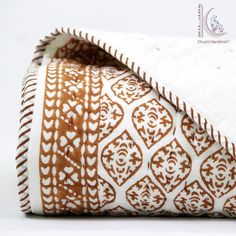 a white and brown patterned pillow on top of a table