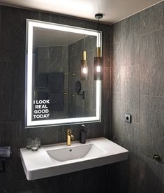 a bathroom sink sitting under a large mirror