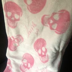 a pink and white blanket with skulls on it