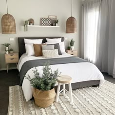 a bedroom with a large bed and two planters on the side of the bed