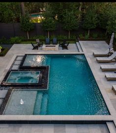 an outdoor swimming pool with lounge chairs around it