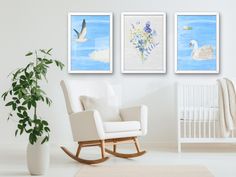 three framed pictures hang on the wall above a rocking chair in a white room with a baby's crib