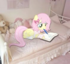 a pink pony laying on top of a bed next to stuffed animals