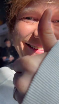 a close up of a person holding something in his hand and smiling at the camera