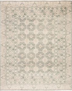 an antique rug with white and grey designs on the bottom, in front of a white background