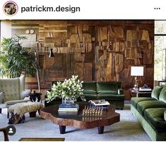 a living room filled with green couches and wooden paneling on the wall behind them