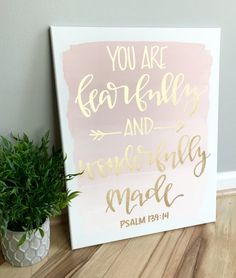 a pink and gold sign with the words you are fearless and courageous made on it next to a potted plant