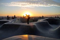 a skateboarder is doing tricks at sunset