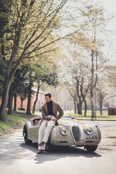 a man sitting on top of an old car