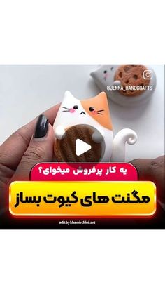 a person holding a cupcake in their hand with an animated cat on the top