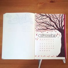 an open calendar book with a tree drawn on it