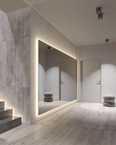 an empty room with two urinals in the wall and lights on the floor