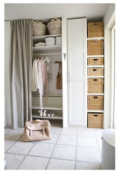 an open closet with clothes and baskets in it