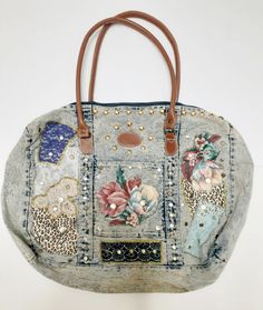 a handbag made out of old jeans with patches and flowers on the front pocket