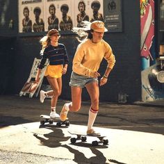 two people riding skateboards down the street