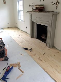 a room that is being remodeled with wood flooring and a vacuum on the ground