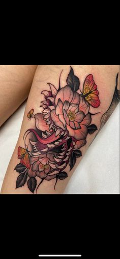 a woman's thigh with flowers on it and butterflies flying around the leg area