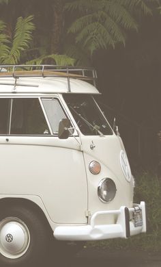 an old vw bus parked in front of some trees