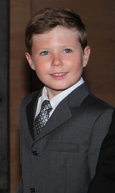 a young boy wearing a suit and tie