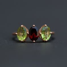 Peridot And Garnet Ring, Three Gemstone Gold Vermeil Ring, 925 Sterling Silver Ring, Handmade Ring, Women's Wedding Ring, Anniversary Gifts Metal: 925 Sterling Silver Gemstone : Peridot And Garnet Stone Color : Green And Red Stone Shape : Oval Stone Setting: Prong Benefits of wearing Green Peridot:- Peridot is one of the few gemstones that occur in only one color: an olive-green. The intensity and tint of the green, however, depends on the percentage of iron in the crystal structure, so the colo Elegant Peridot Gemstone Stackable Rings, Peridot Three Stone Jewelry As Gift, Three Stone Peridot Jewelry As Gift, Peridot Three Stone Ring, Three Stone Peridot Ring Jewelry, Three Stone Peridot Ring, Anniversary Peridot Multi-stone Rings, Elegant Three Stone Peridot Ring, Round Peridot Three-stone Jewelry