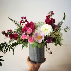 a person holding a vase with flowers in it