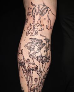 a man's leg with tattoos on it that has animals and plants all over it