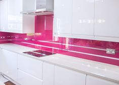 a kitchen with white cabinets and pink backsplashes on the countertops,