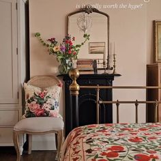 a bedroom with a bed, chair and mirror on the wall next to each other