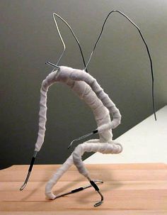 a sculpture made out of yarn sitting on top of a wooden table