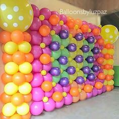 balloons are arranged in the shape of a caterpillar and polka dots on a wall