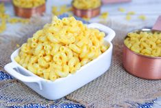 macaroni and cheese is in a white bowl next to some other food items