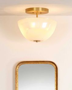 a bathroom with a mirror, sink and light fixture