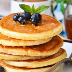 a stack of pancakes with blueberries and syrup on the top are ready to be eaten