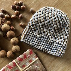 a knitted hat, wrapping paper and nuts on a table