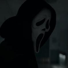 a person wearing a scary mask in the dark