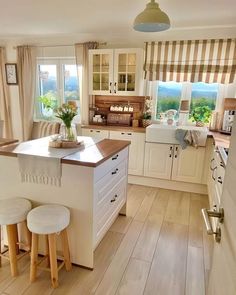 a kitchen with two stools in front of the counter and an island next to it