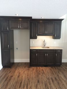 an empty kitchen with wooden floors and cabinets