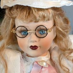 a close up of a doll with glasses and a hat on it's head