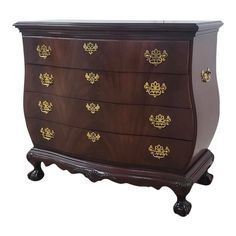 an antique chest of drawers with gold decorations on the top and bottom, against a white background