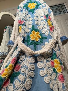 an elaborately decorated coat is displayed in front of a mirror