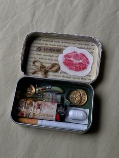 an open tin can filled with assorted items on top of a sheeted surface