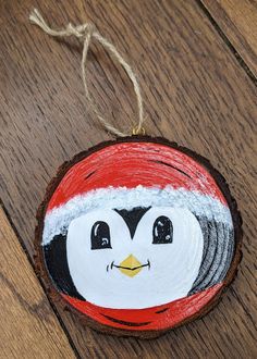 a painted wooden ornament with a penguin on it