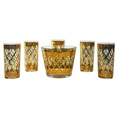 four yellow glass vases sitting next to each other