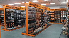 the store is filled with many different tools and equipment in orange stands, all on display