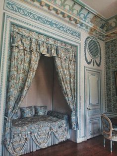 an ornate bedroom with blue walls and curtains