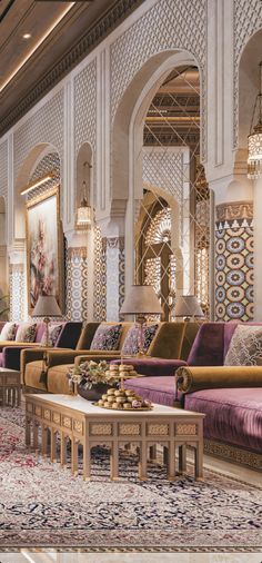 an ornately decorated lobby with purple couches and rugs on the floor in front of windows