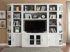 a white entertainment center with bookshelves and a flat screen tv