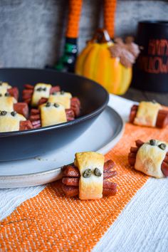 small pigs in a blanket made out of marshmallows on a table with pumpkins