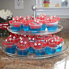 some cupcakes with googly eyes are on a cake platter in the kitchen